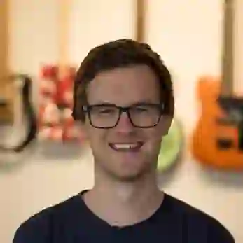 Mein Gesicht mit meinen gebauten Gitarren verschwommen im Hintergrund